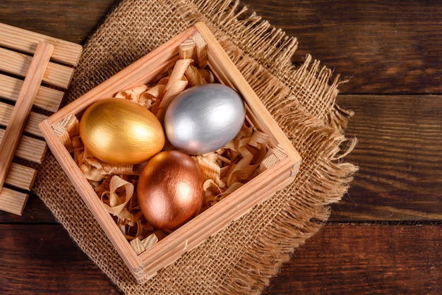 Ovos de Páscoa em caixa de madeira de presente na mesa de madeira escura. Preparação para o feriado