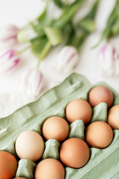 Ovos de Páscoa em uma caixa verde e flatlay de tulipas