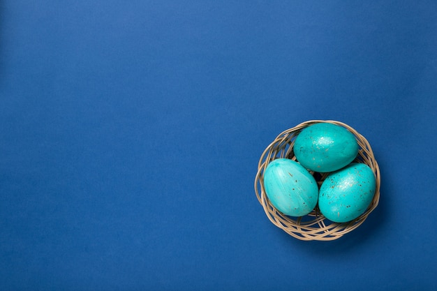 Ovos de Páscoa em uma cesta em um azul