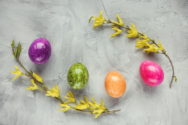 Ovos de páscoa multicoloridos e flores amarelas primaveris