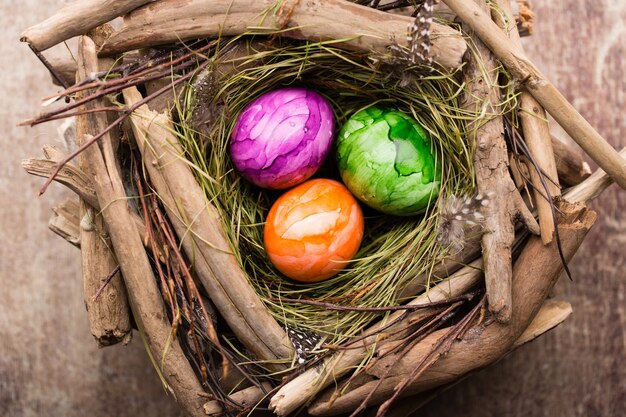 Ovos de Páscoa no ninho em fundo de madeira rústico