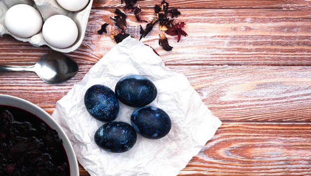 Ovos de páscoa pintados com corante natural em azul na mesa o processo de tingir ovos em casa