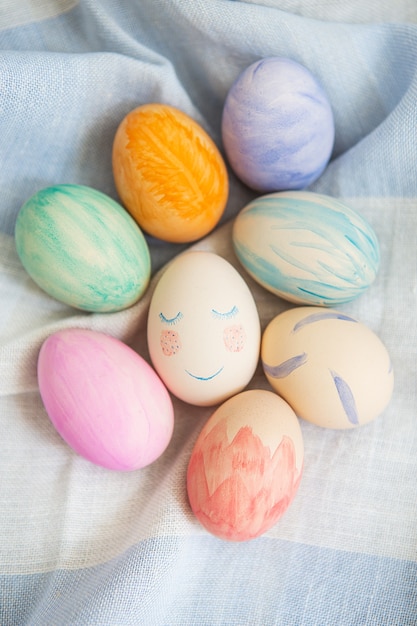 Ovos de Páscoa pintados em cores vivas e multicoloridas em uma toalha de mesa de linho