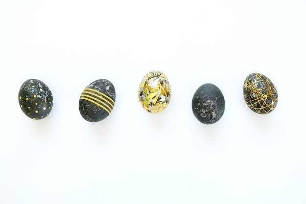 Foto ovos de páscoa pretos com padrão de ouro no fundo branco