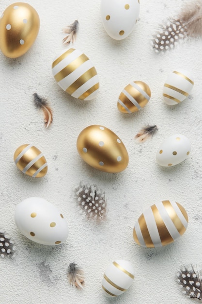 Ovos de Páscoa são pintados com tinta dourada em um fundo de concreto cinza