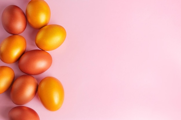 Ovos dourados brilhantes em um fundo rosa Feliz Páscoa Lugar para texto