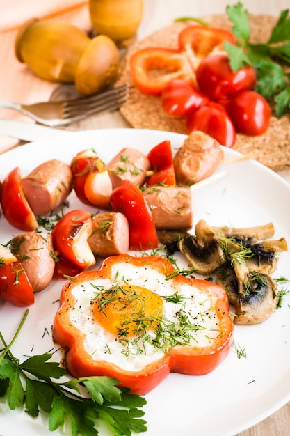 Ovos em pimentos, cogumelos e salsicha com pimentos no espeto