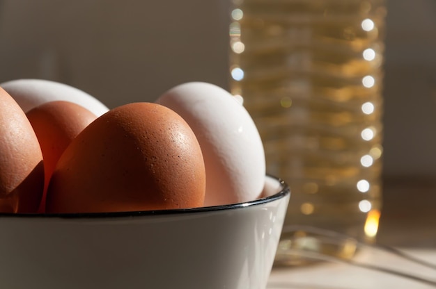 Ovos em um copo de cerâmica closeup Cozinhar na cozinha Ovos brancos e marrons Uma garrafa de óleo de perto Bata para bater massa e creme