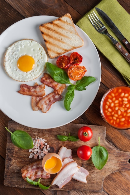 Ovos fritos com bacon no café da manhã em tábuas rústicas de madeira, fundo de comida