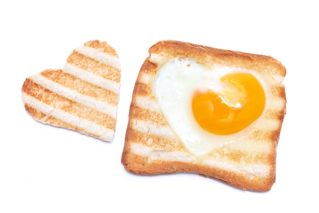 Ovos fritos em forma de coração em um pão torrado com marcas de grelha isoladas no fundo branco