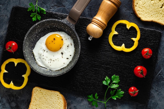 Ovos fritos em uma frigideira com legumes frescos e especiarias. Conceito de menu e publicidade.