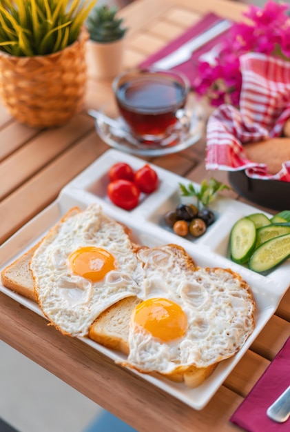 Ovos fritos virados para cima no pão com acompanhamentos. conceito de café da manhã