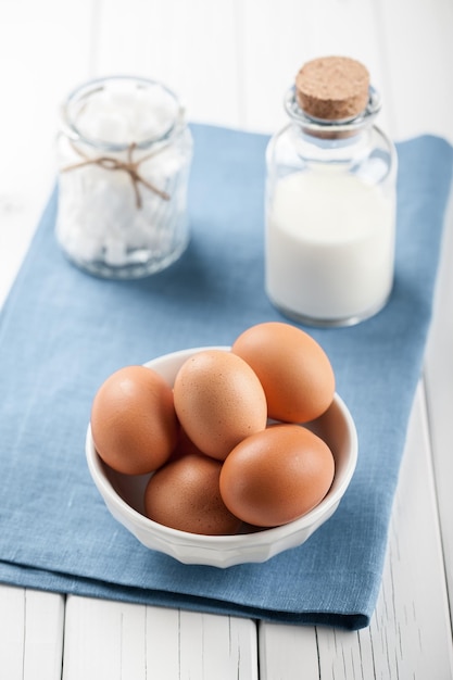 Ovos, leite e açúcar branco na mesa de madeira