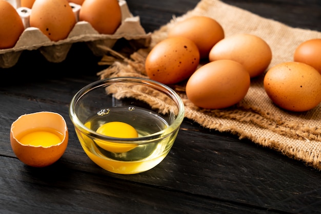 Ovos marrons com um quebrado e gema de ovo