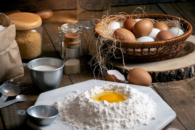 Ovos, massa e farinha na mesa de madeira com fundo splat para um objeto em uma padaria