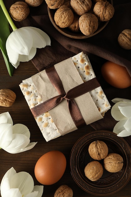 Foto ovos matzo nozes e flores em toalha em fundo de madeira vista superior