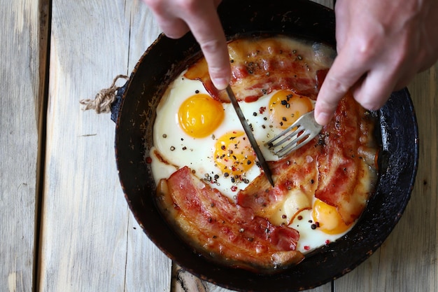 Ovos mexidos com bacon em uma frigideira