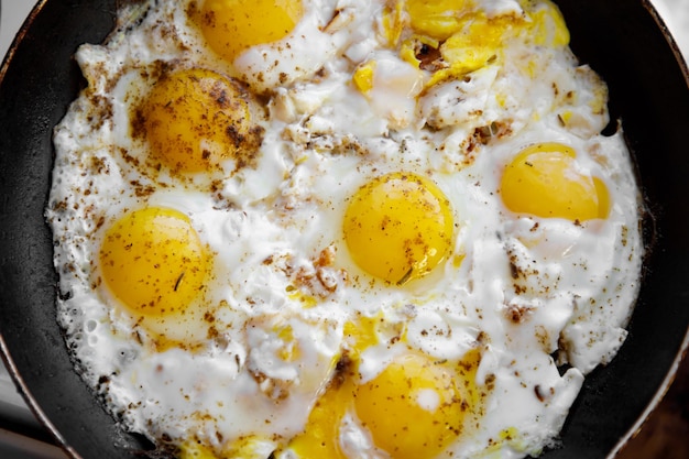 Ovos mexidos com especiarias são cozidos em uma frigideira.