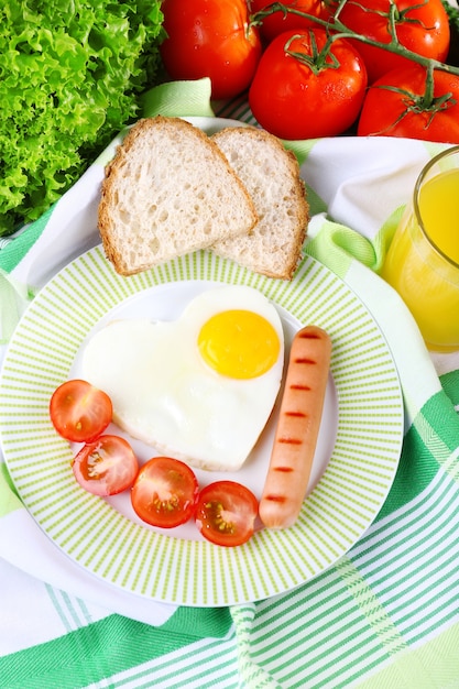 Ovos mexidos com salsicha e legumes servidos no prato no tecido