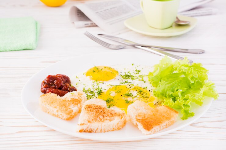 Foto ovos mexidos, pão frito, ketchup e alface folhas em um prato na mesa. café da manhã pronto para comer