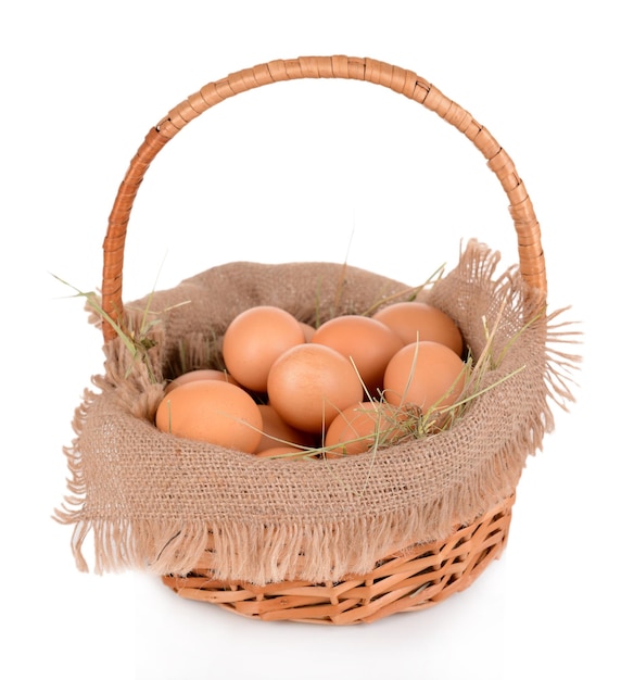 Foto ovos na cesta de vime isolados no branco