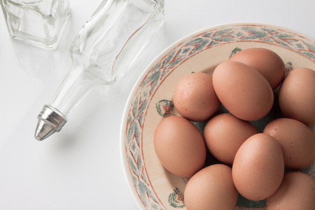 Ovos no prato com garrafa no fundo branco