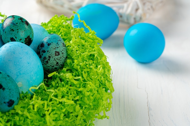Ovos pintados de azul em um ninho para a Páscoa