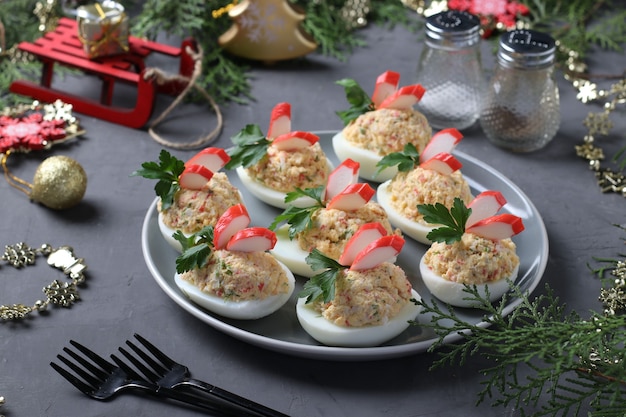 Ovos recheados com palitos de caranguejo, um delicioso lanche festivo. Fechar-se. Composição de Natal. Formato horizontal