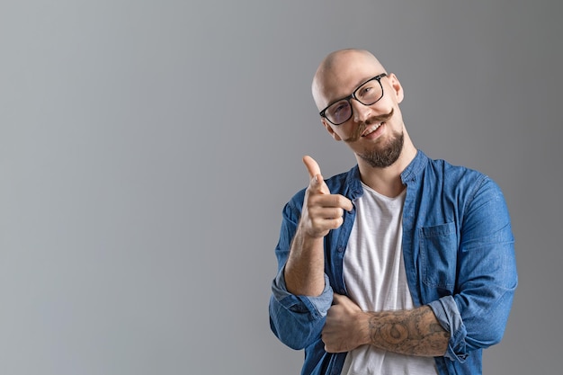 Oye, alegre chico barbudo apuntando a la cámara con un hombre positivo que indica que alguien dice gotcha a