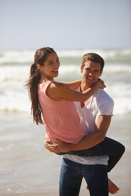 Oye, no mires a escondidas Foto de una pareja joven jugando en la playa