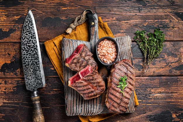 Oyster Top Blade Rindersteak gegrillt auf Sommer BBQ Holzhintergrund Draufsicht