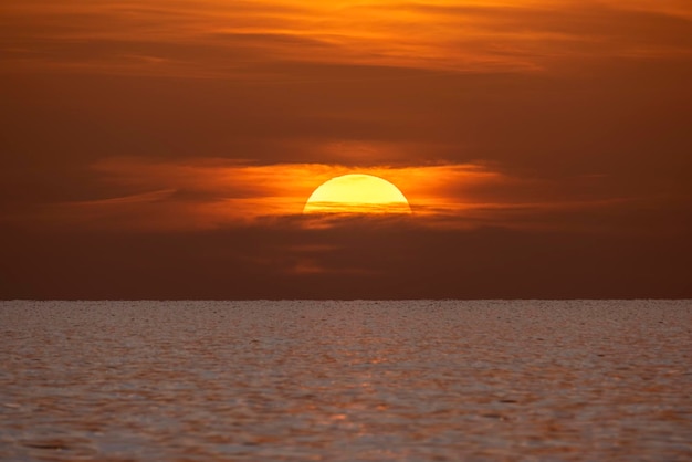 Ozeansonnenuntergang Große weiße Sonne auf dramatischem hellem Himmelshintergrund weicher Abendhorizont über dunklem Wasser des Meeres