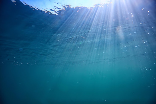 Ozeanwasser blauer Hintergrund Unterwasserstrahlen Sonne / abstrakter blauer Hintergrund Naturwasser