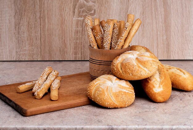 P¡risp Brot mit Brötchen. Französische Baguettes. Frisches Knäckebrot. Brothintergrund. Unterschiedliche Rasse auf hölzernem Hintergrund.