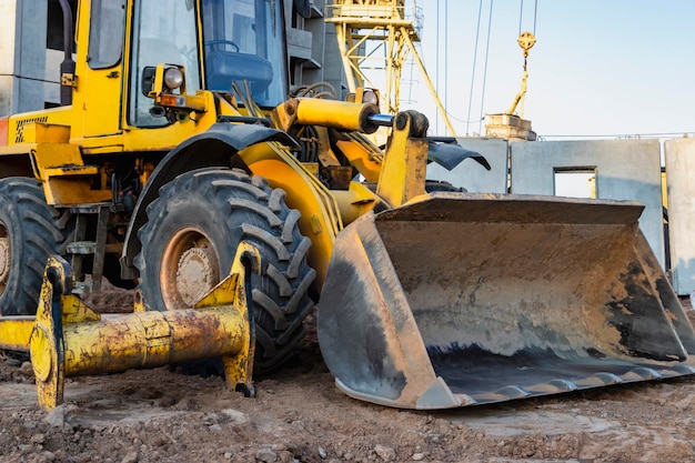 Pá carregadeira pesada com balde em um canteiro de obras Equipamento para transporte de terraplenagem e carregamento de materiais a granel terra areia brita