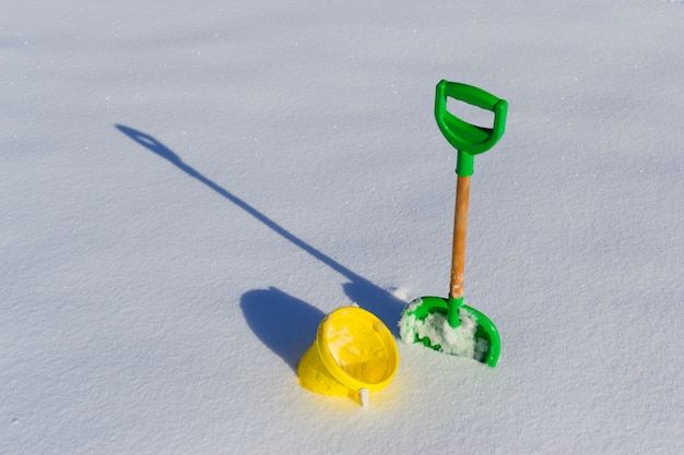 Pá e balde na neve limpa fresca e profunda