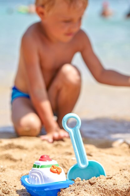 Pá e pá de baldes de brinquedos de praia infantil na areia em um dia ensolarado