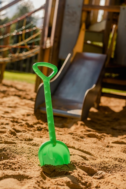 Pá infantil de plástico verde no playground