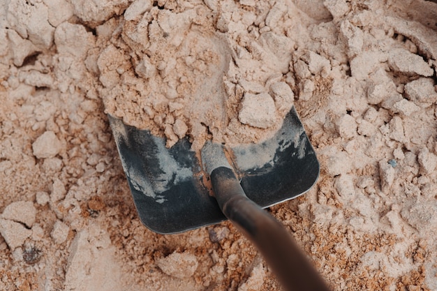 Pá preta na areia. Obras de construção