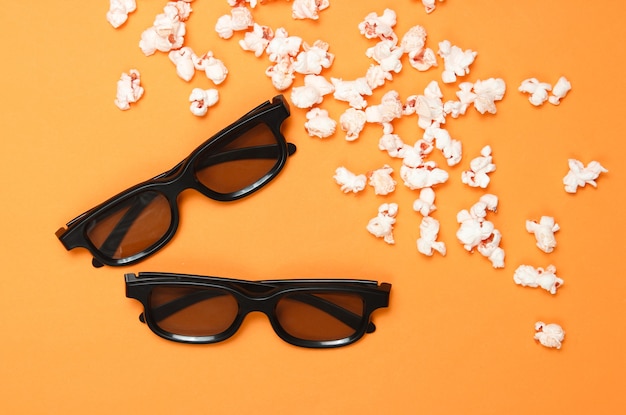 Paar 3D-Brille, Popcorn auf orange Hintergrund