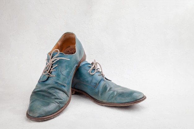 Paar alte blaue Lederschuhe mit Schnürsenkeln