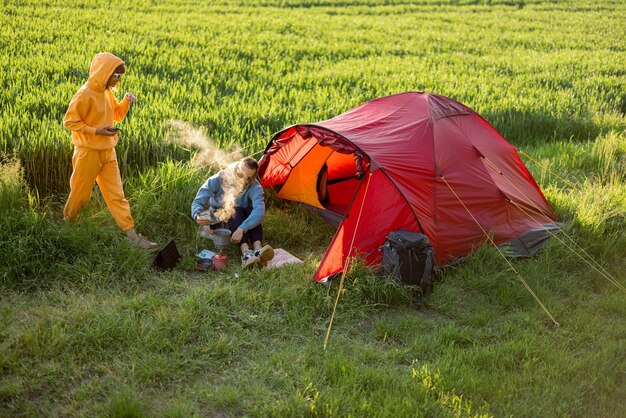 Paar am Campingplatz mit Zelt auf der grünen Wiese