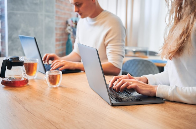 Paar arbeitet an Laptops in der Küche