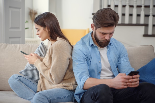 Paar auf der Couch nach einem Streit zu Hause im Wohnzimmer