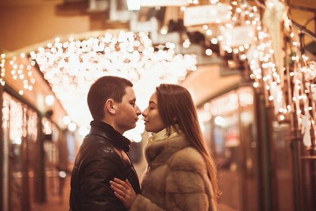 Paar auf der Straße vor der Weihnachtszeit. Bokeh Lichter Dekoration Hintergrund