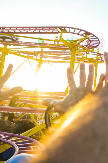 Foto paar auf einer achterbahn mit den armen in der luft amüsiert und aufgeregt warten auf den steilen abstieg sonniger nachmittag mit spaß konzept der freizeit und heiterkeit