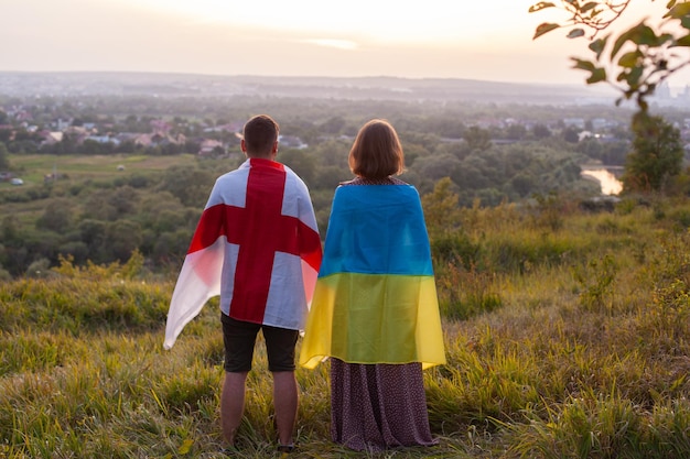 Paar bedeckt mit Flaggen der Ukraine und Englands