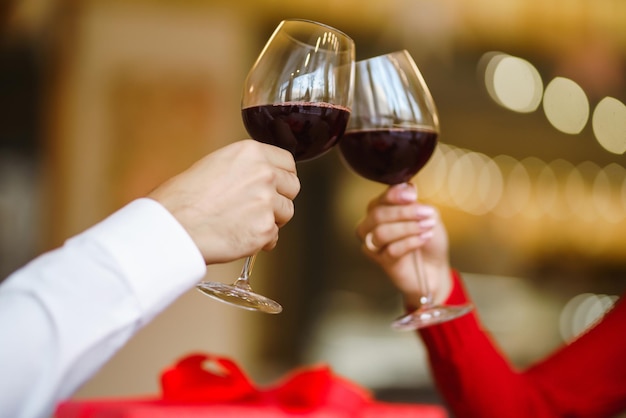 Paar Clink Gläser mit Rotwein Liebhaber geben einander Geschenke Schönes romantisches Abendessen