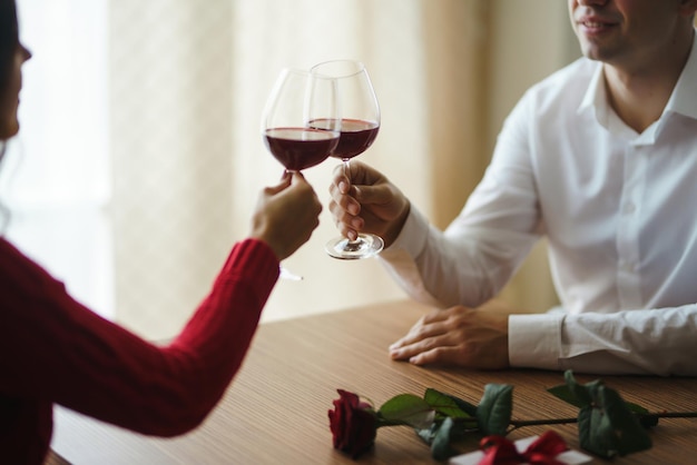 Paar clink gläser mit rotwein liebhaber geben einander geschenke schönes romantisches abendessen