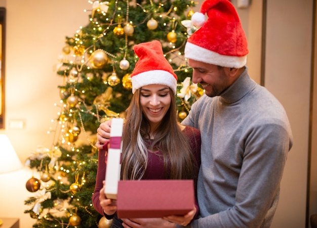 Paar, das ein Weihnachtsgeschenk öffnet